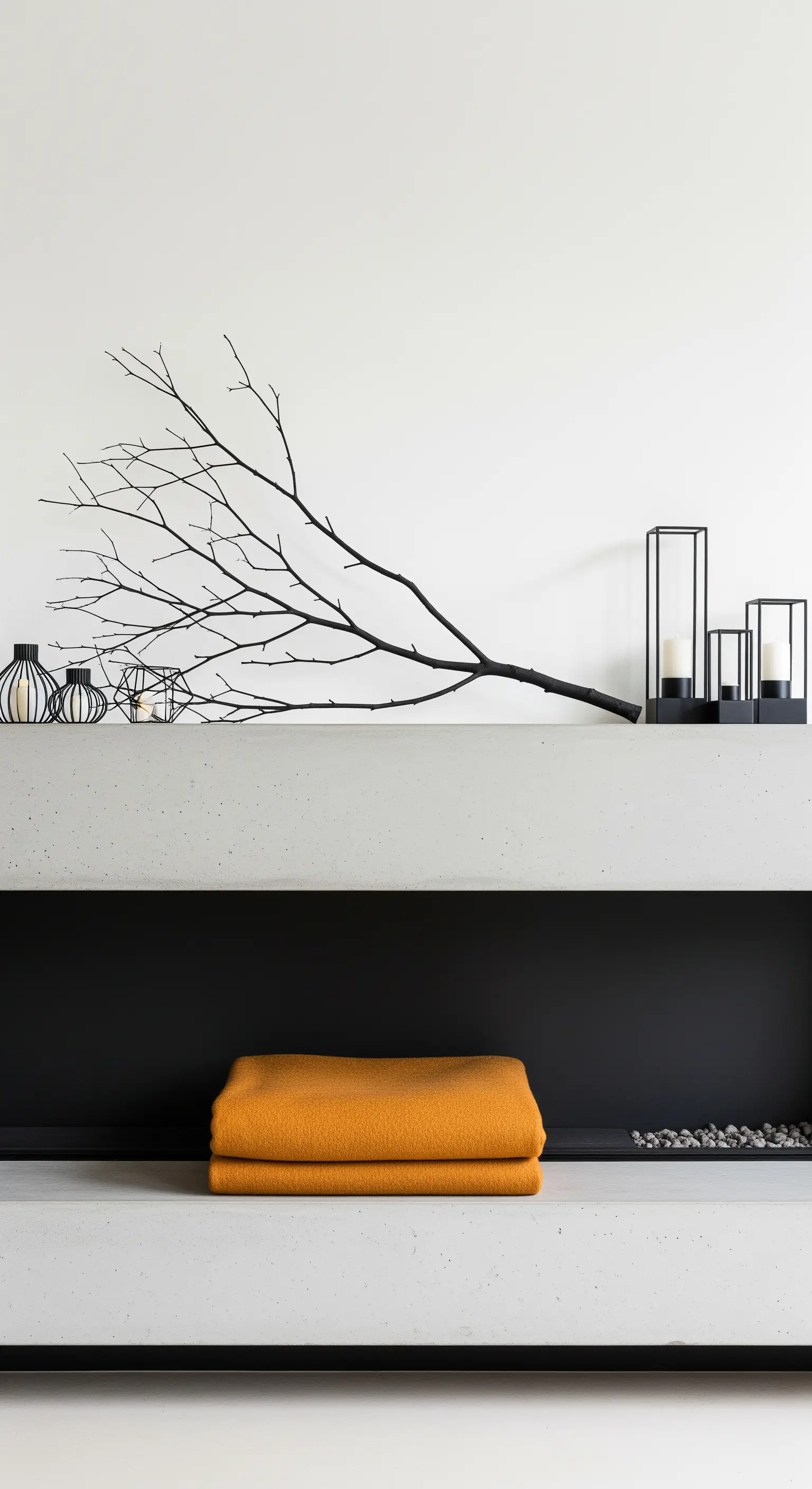 Betonkamin mit einem schwarzen Ast, schwarzen Laternen und einer ockerfarbenen Decke.