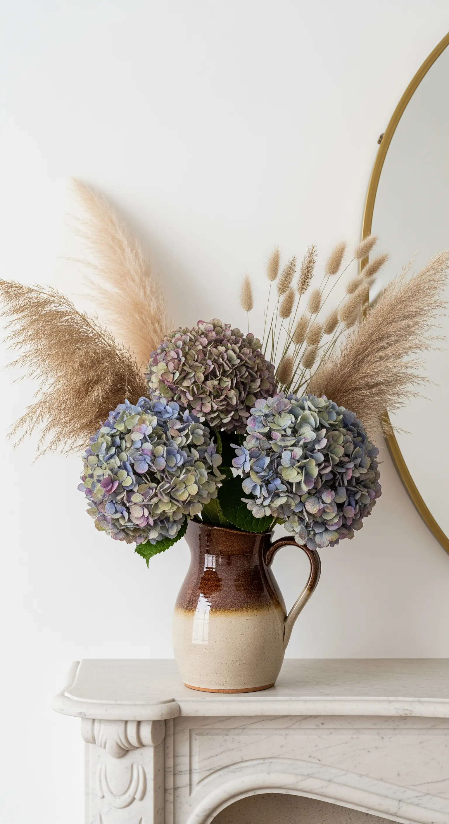 Ein Strauß aus getrockneten Hortensien und Pampasgras in einer rustikalen Keramikkanne