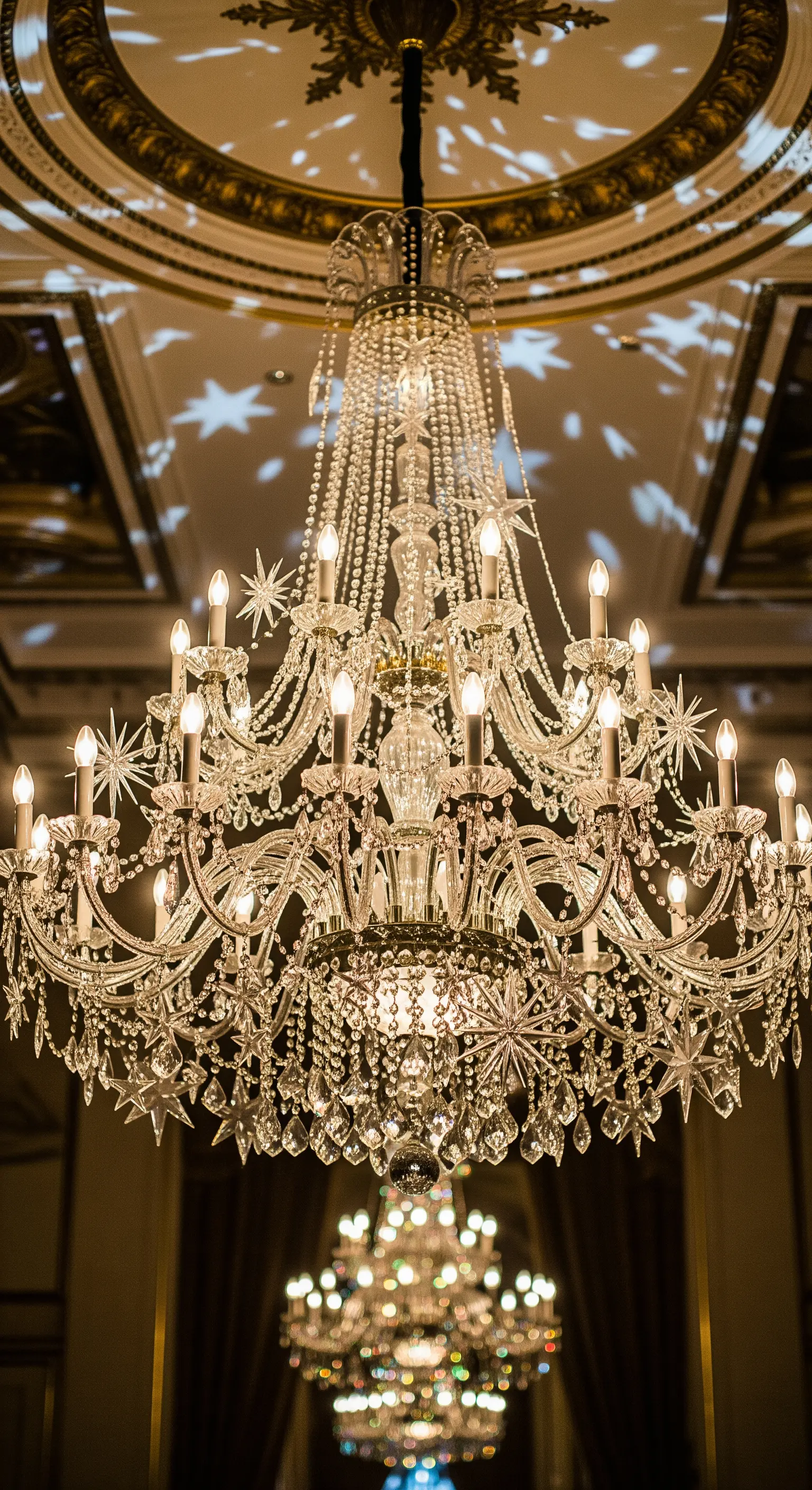 Kronleuchter mit sternförmigen Lichtprojektionen an Decke und Wänden