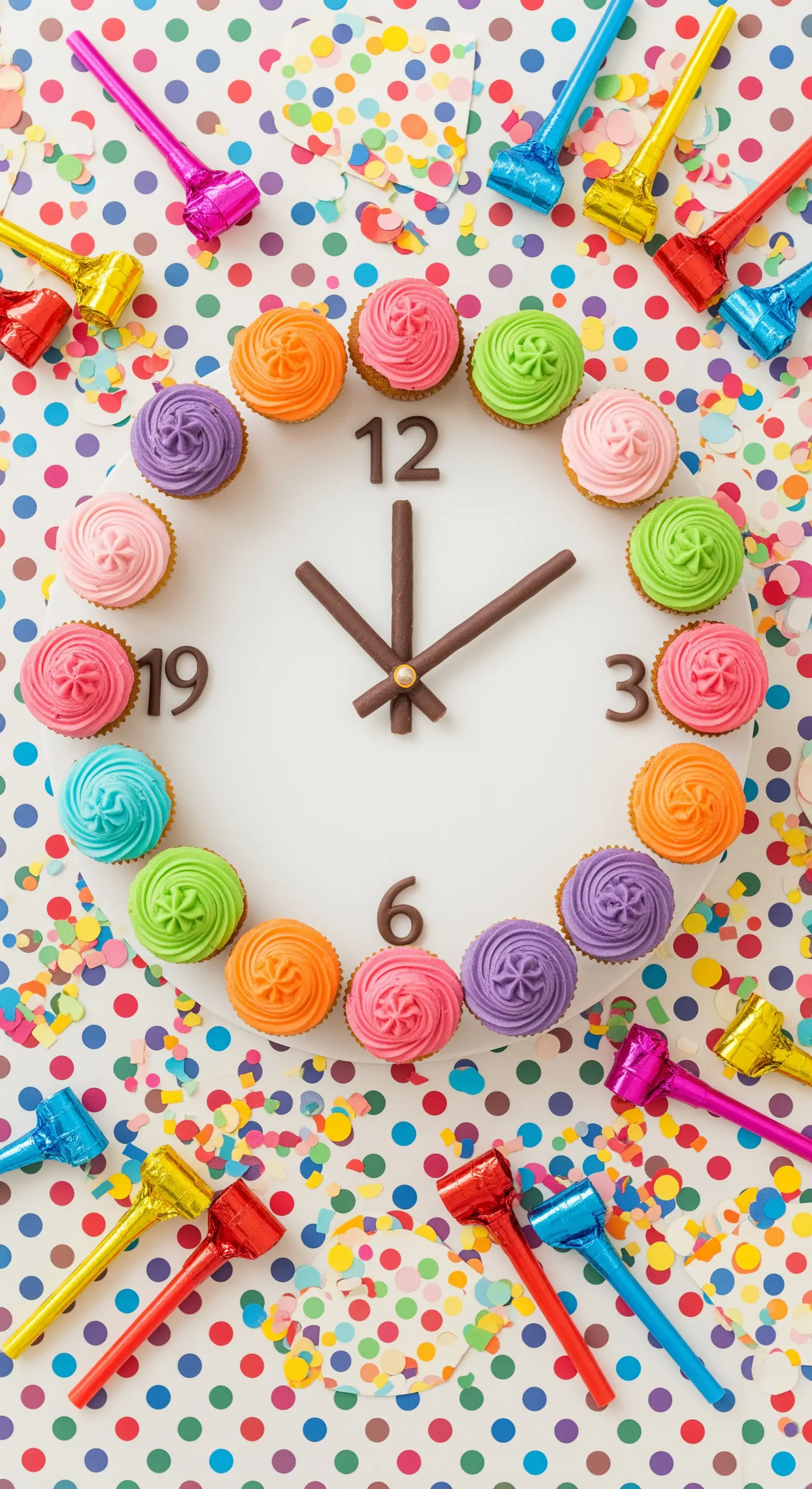 Neujahrs-Countdown-Uhr aus bunten Cupcakes auf Konfetti-Hintergrund.