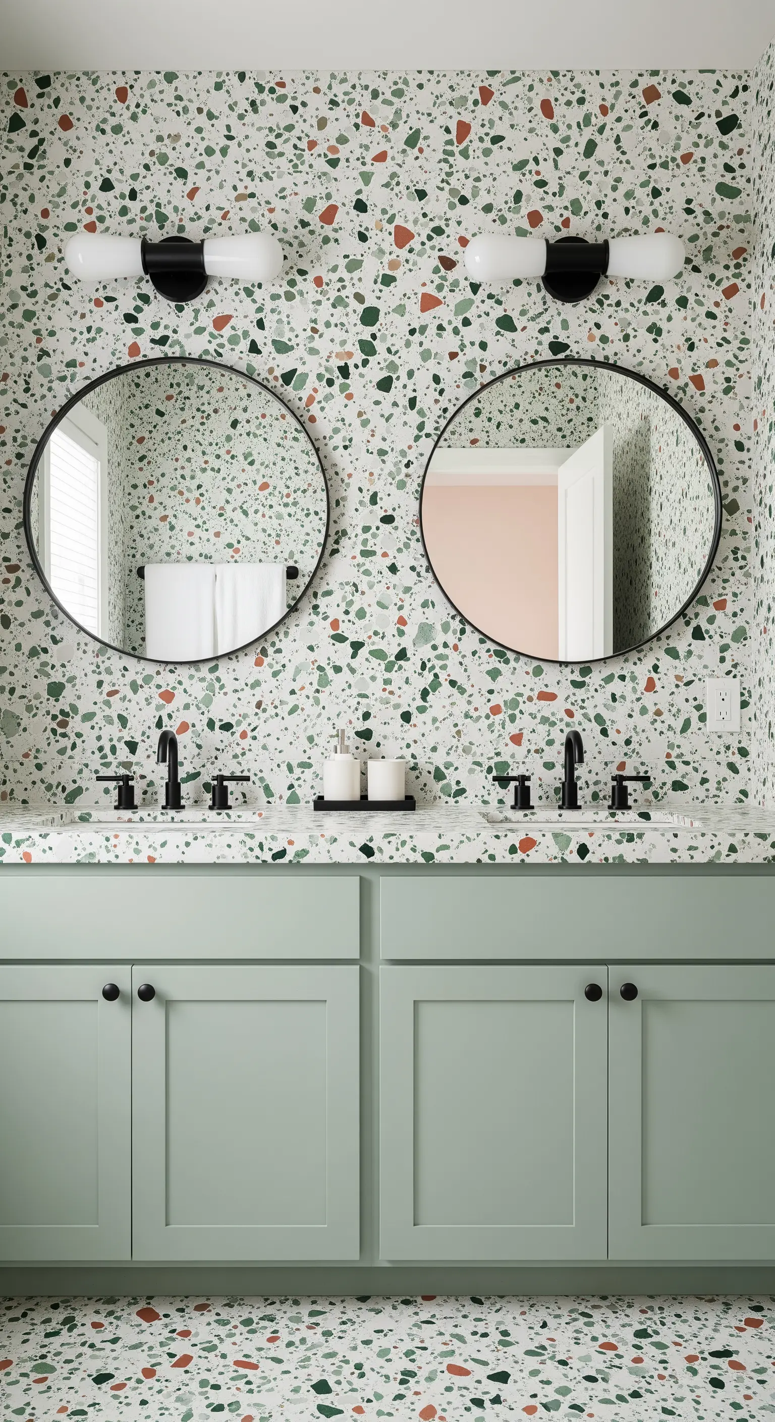 Salbeigrüner Waschtisch in einem Badezimmer mit buntem Terrazzo-Muster.