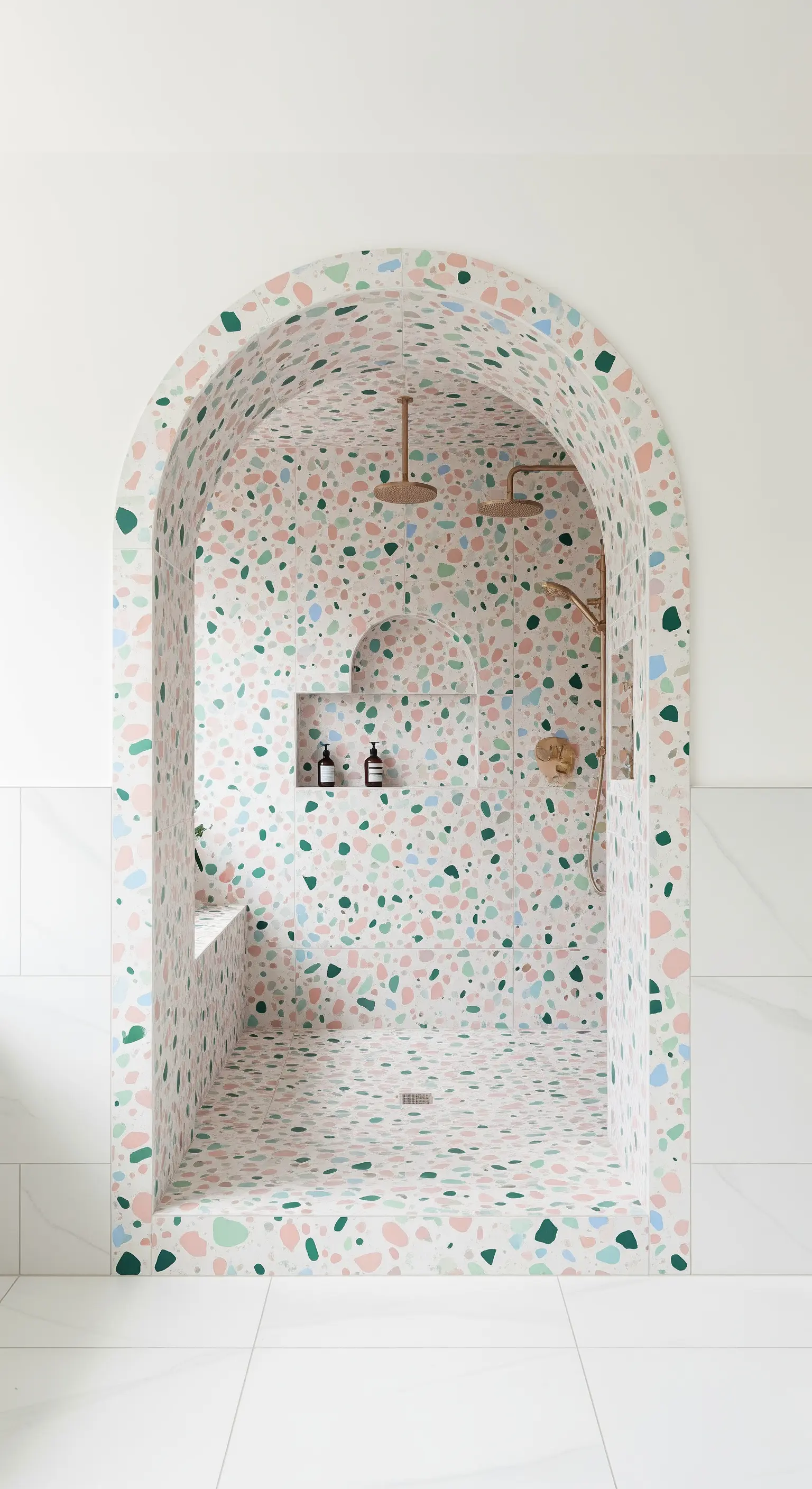 Gewölbte Walk-in-Dusche, die vollständig mit bunten Terrazzo-Fliesen verkleidet ist.