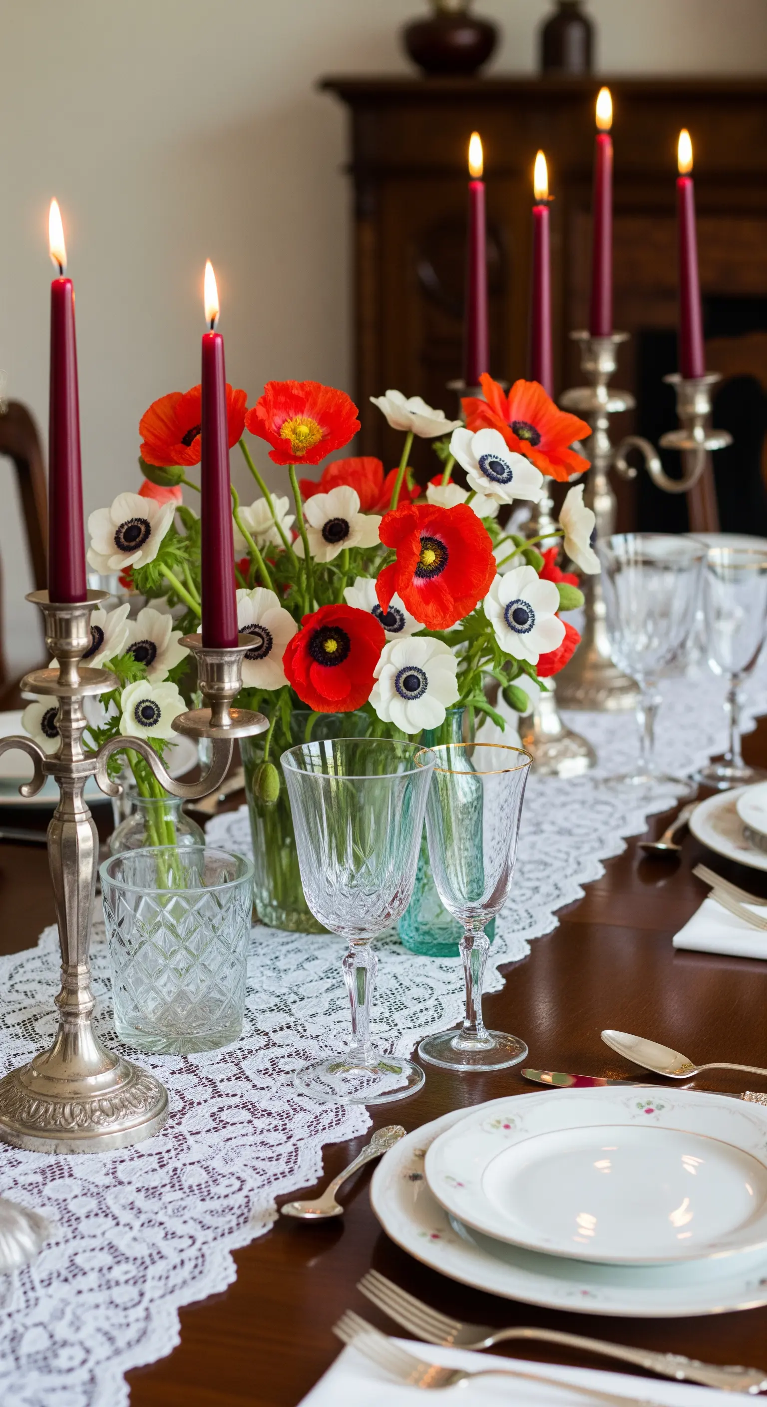 Rote Mohnblumen und weiße Anemonen mit silbernen Kerzenleuchtern und Spitzenläufer