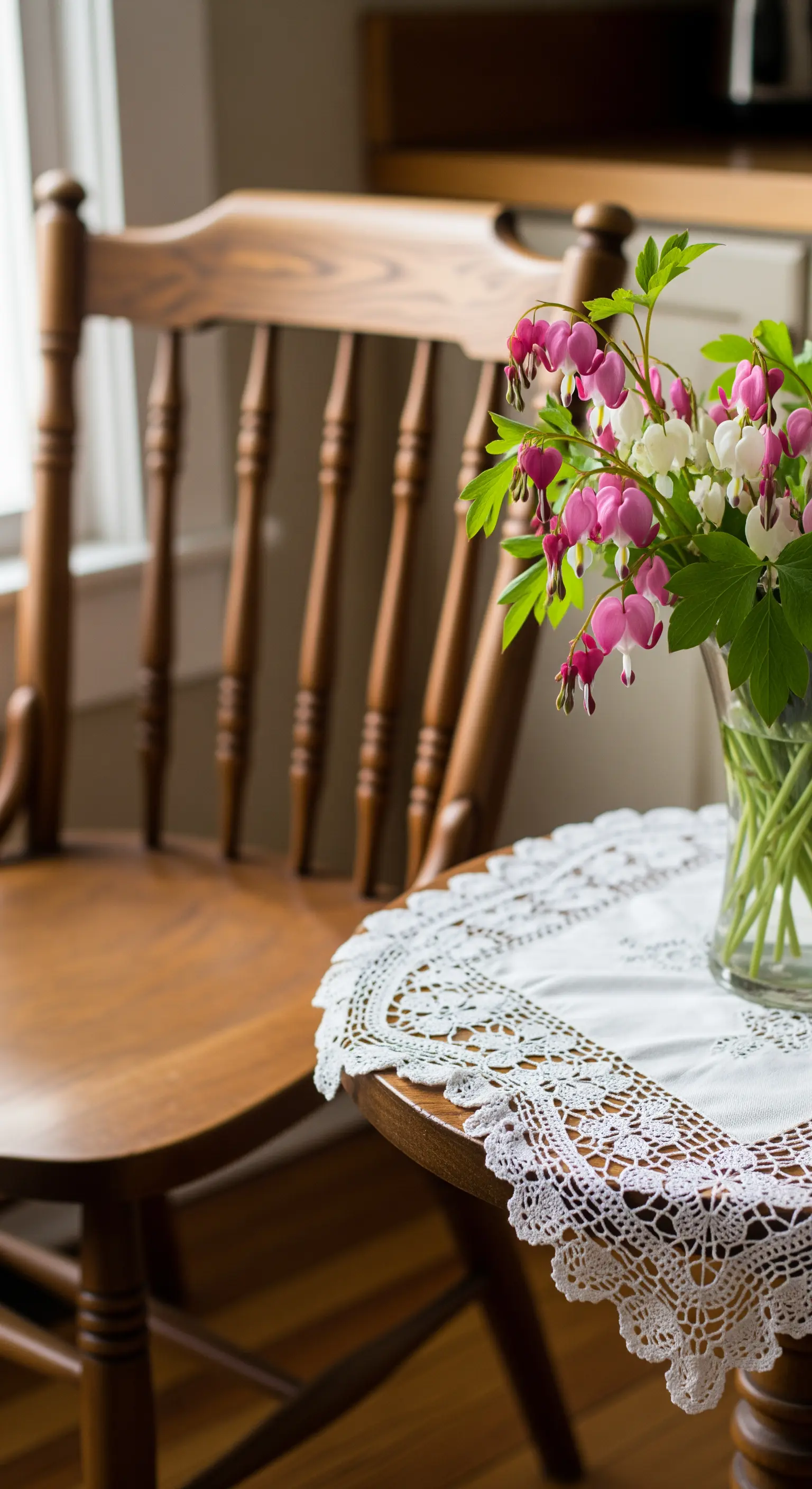 Herzblumen in Vase auf Beistelltisch mit Spitzendecke