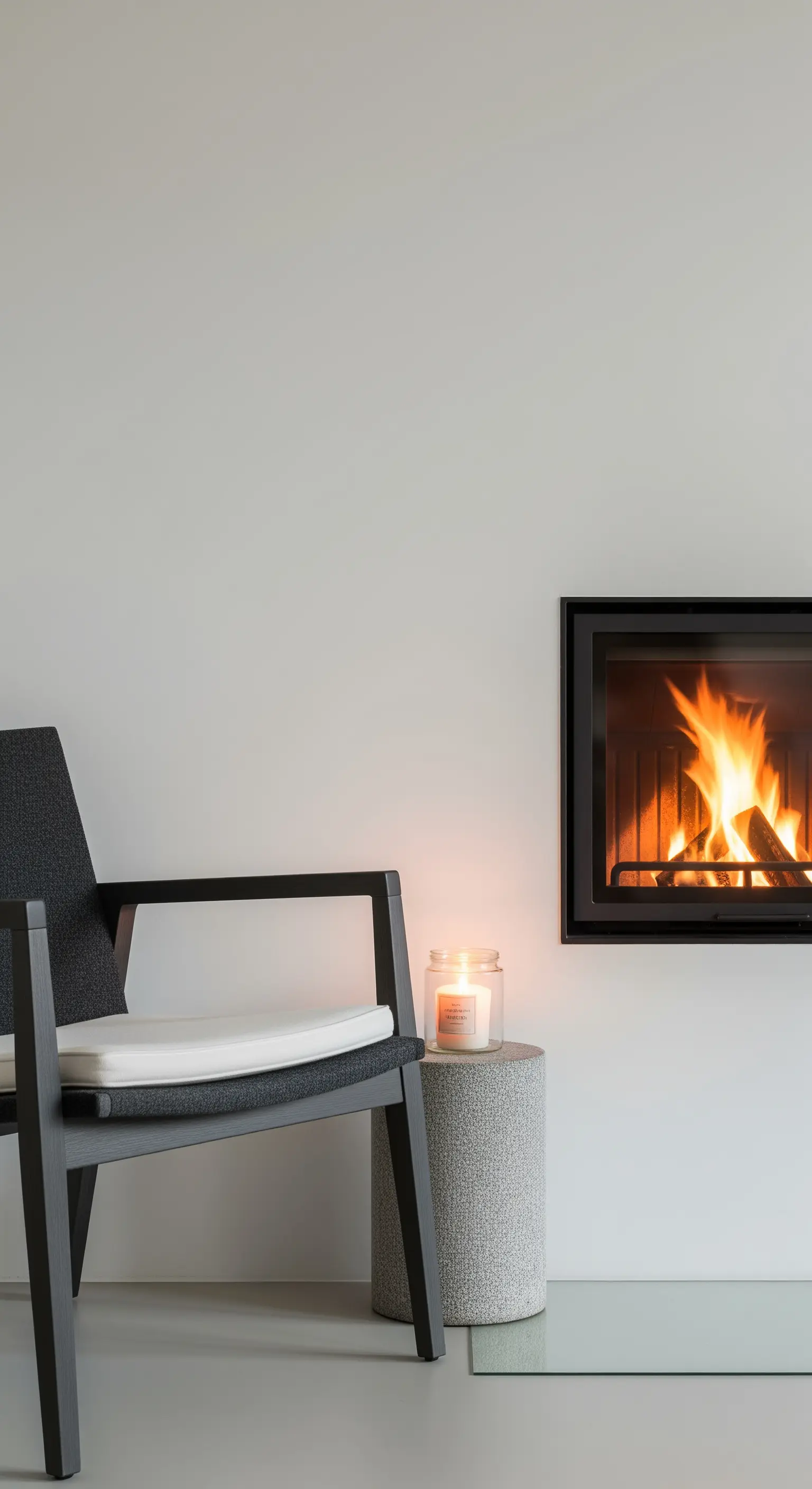Moderner Kamin mit Sessel, Beistelltisch und Duftkerze.