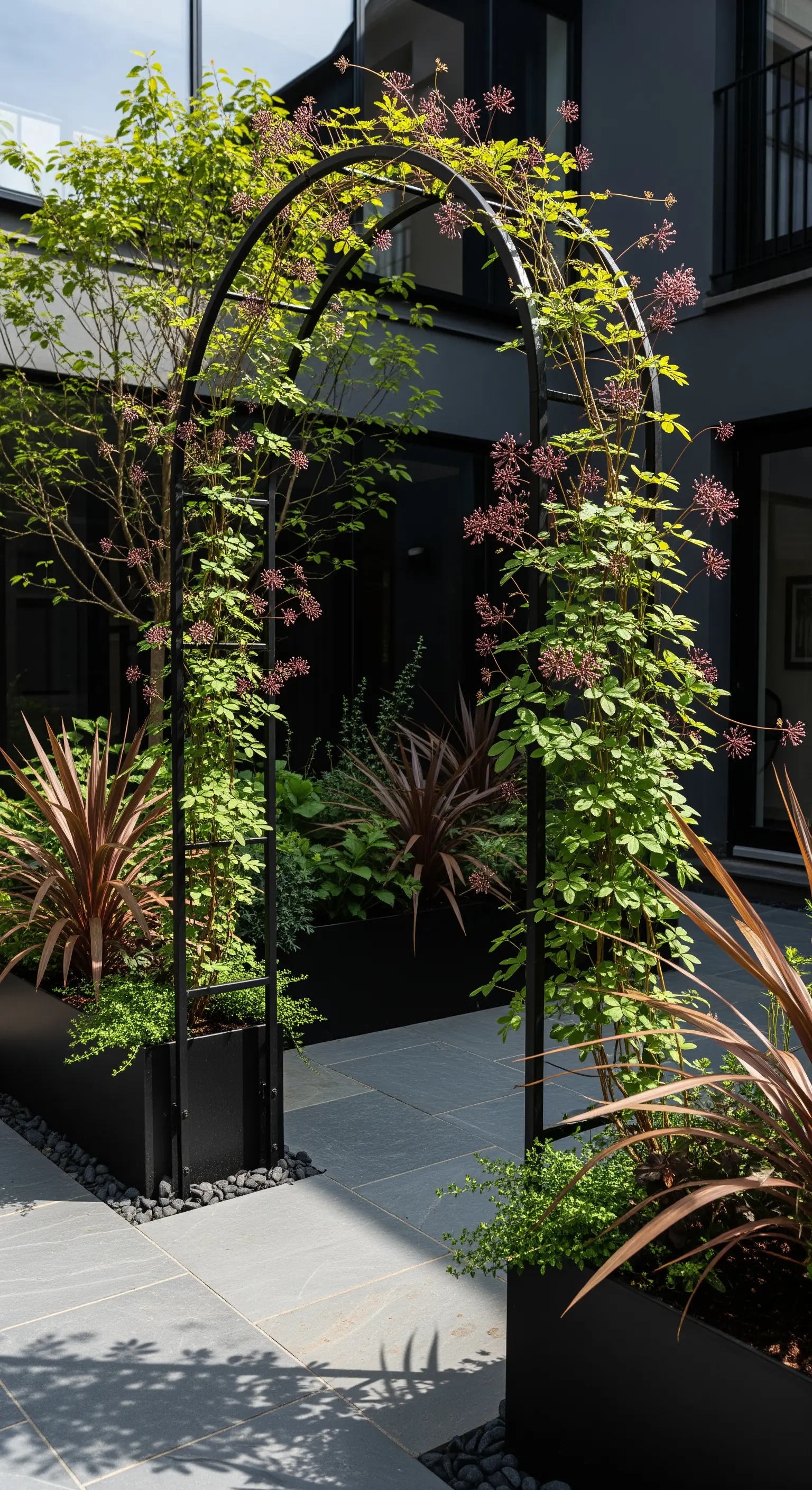 Schwarzer Metallbogen, moderne Pflanzen, minimalistischer Hofgarten