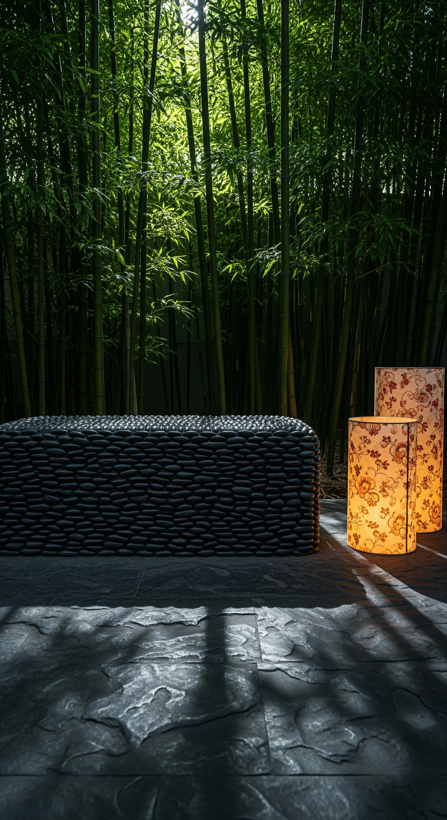 Steinbank vor Bambuswand, beleuchtet von zwei gemusterten Papierlaternen